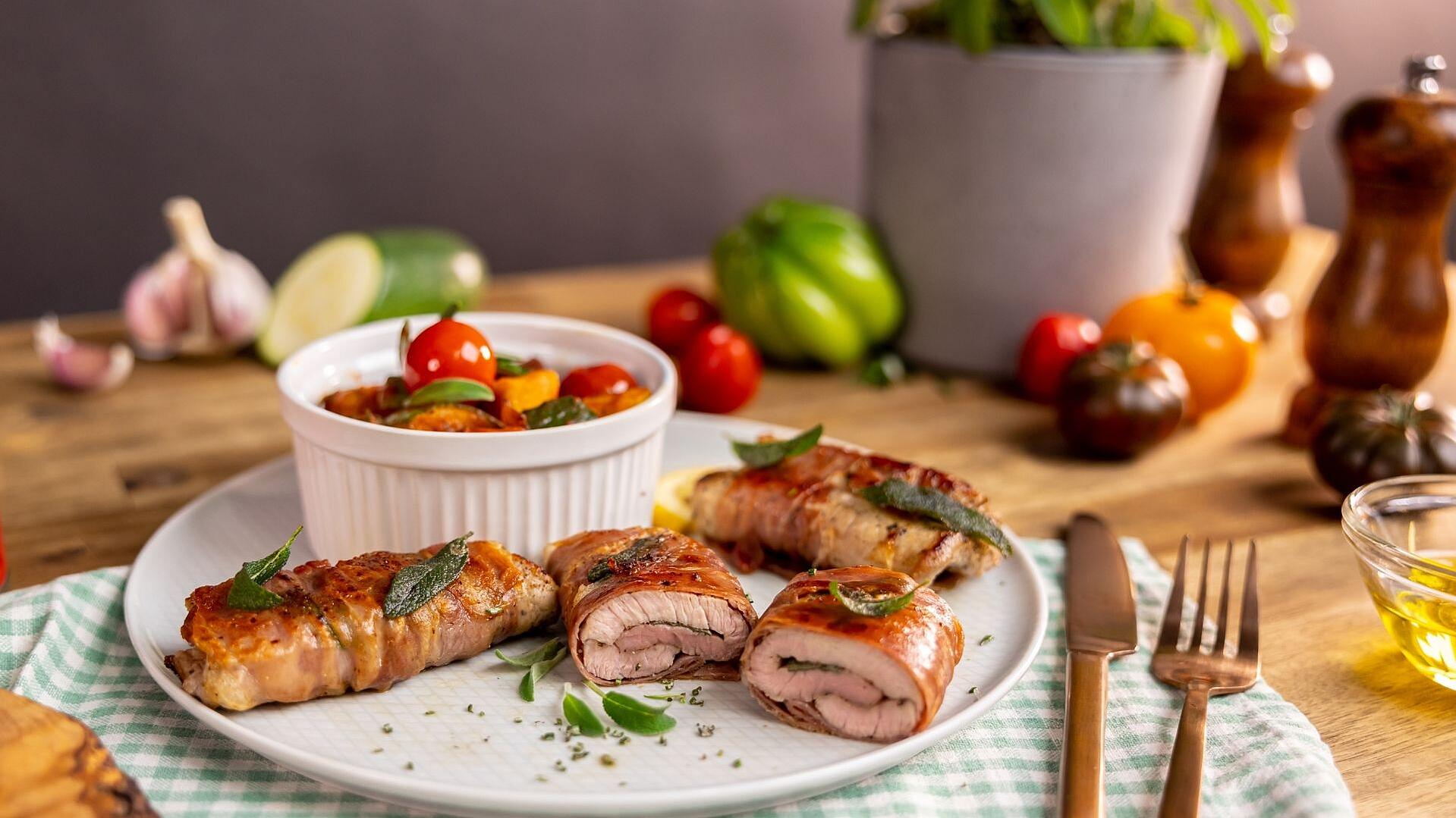 Ein Teller mit Kalbsschnitzel und einem kleinen Schälchen gefüllt mit Gemüse