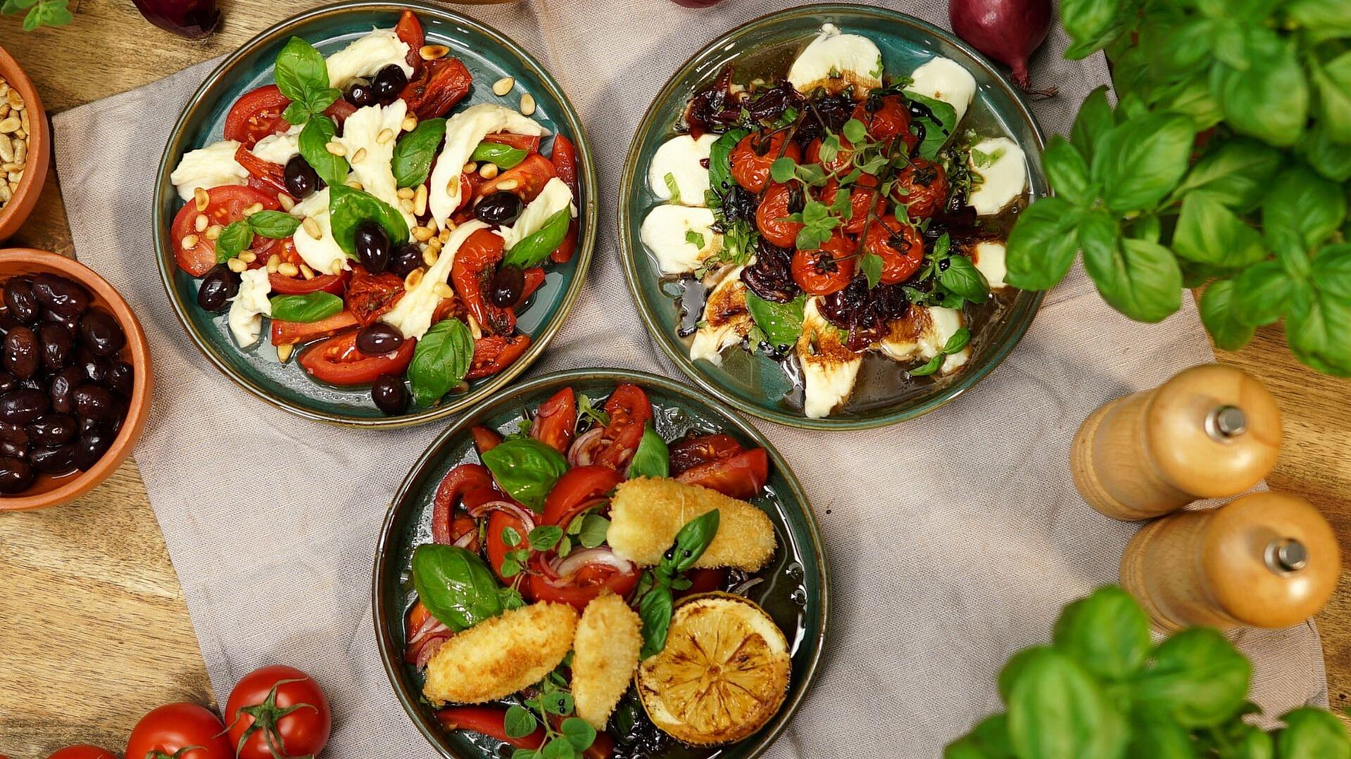 Drei Teller mit unterschiedlichen Varianten von Insalata Caprese. Klassisch mit Tomaten-Mozzarella, mit gebackenem Mozzarella und mit geschmorter Tomate.