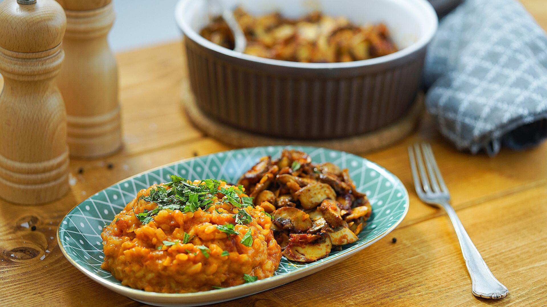 Ein Teller mit Tomaten-Risotto und Knoblauchpilzen