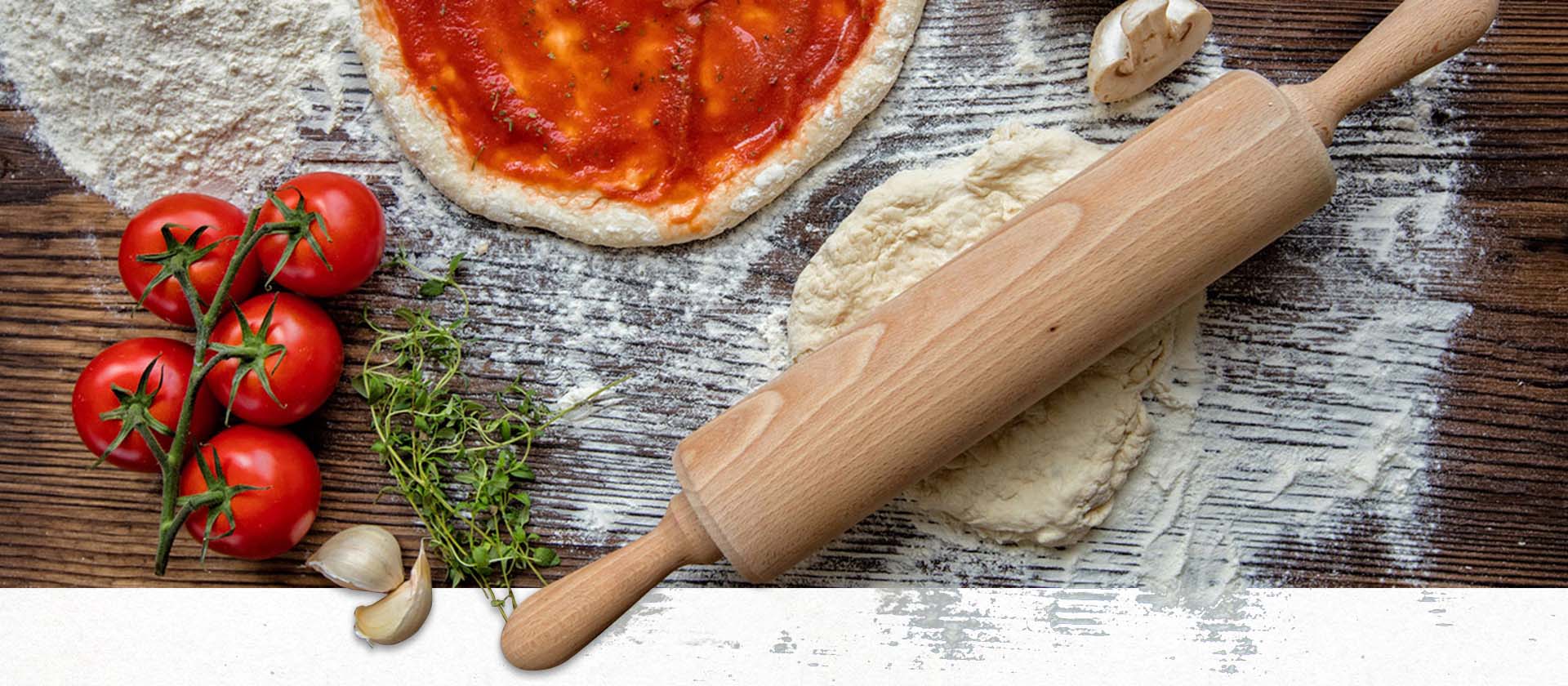Pizzadough with ingredients on wood table 